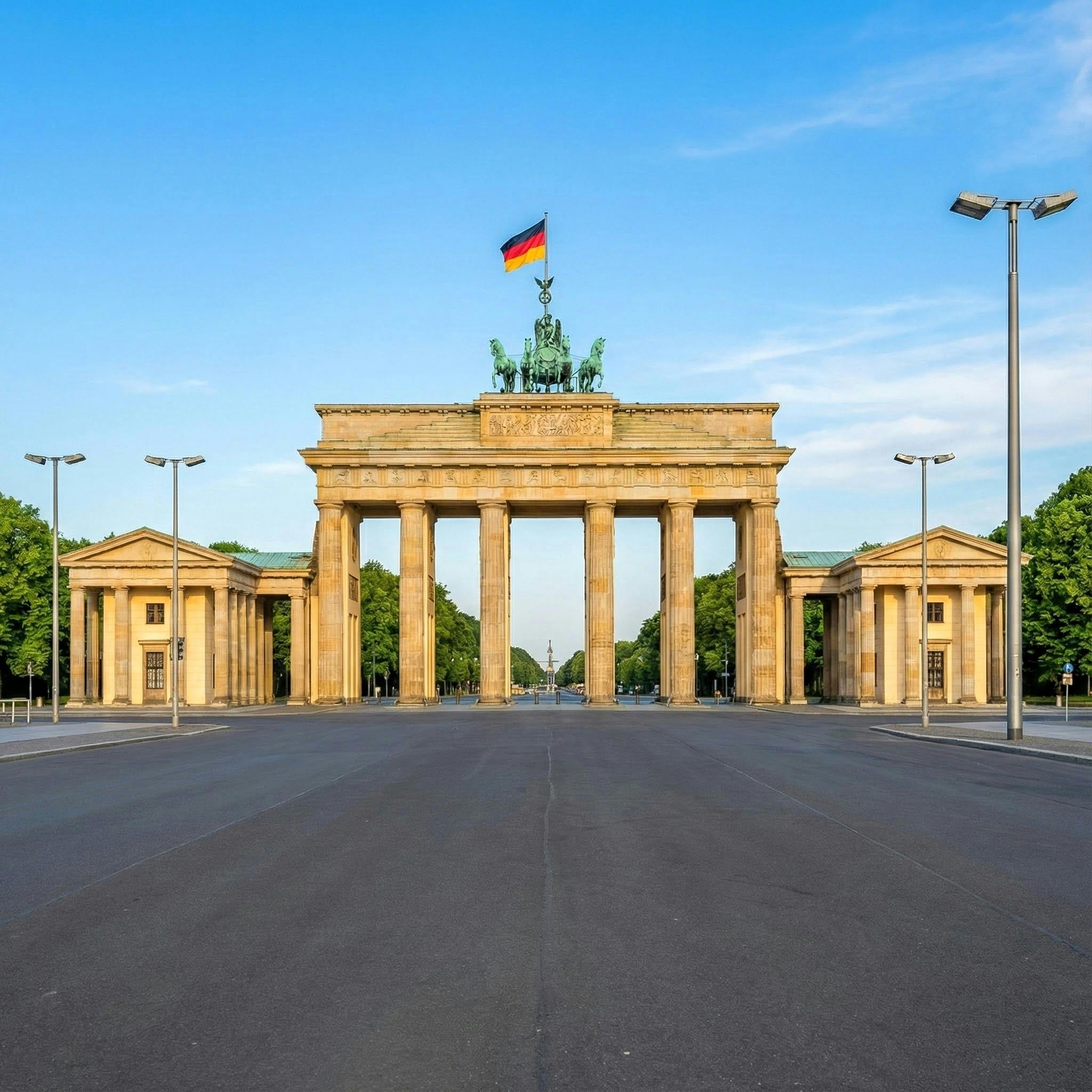 Scenic view of the iconic Brandenburg Gate in Berlin under a clear blue sky.